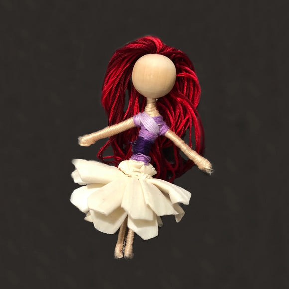 Dahlia from front showing red hair, purple shirt and raw flower skirt
